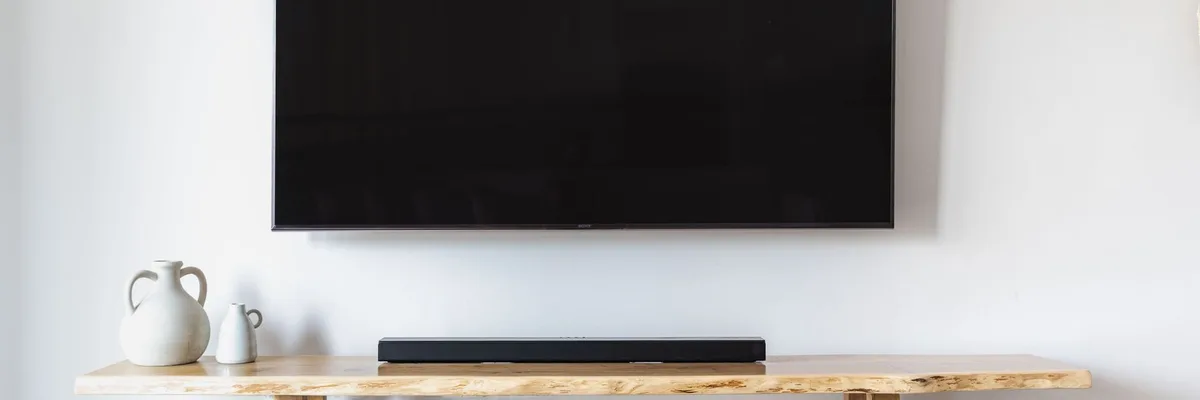 Salon minimaliste élégant avec un téléviseur à écran plat fixé au mur et une console en bois.